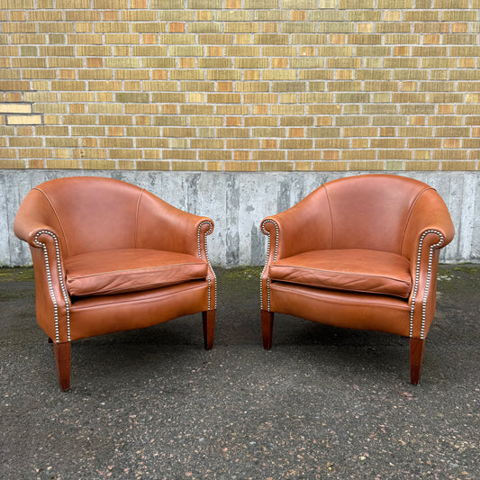 Paret clubfåtöljer i skinn