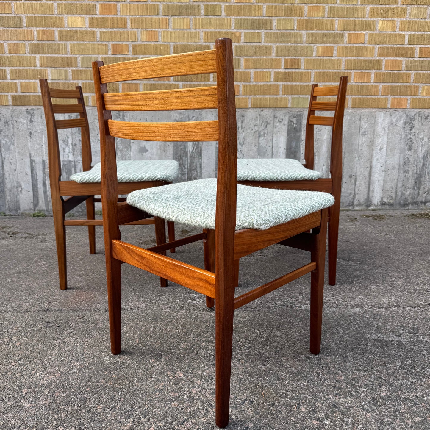 Set med tre matstolar i teak med senare klädsel